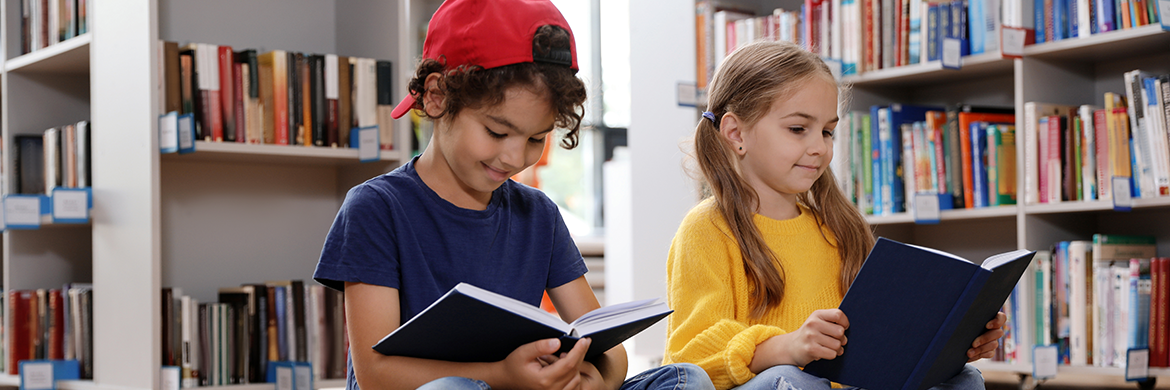 Boy and girl in library reading books